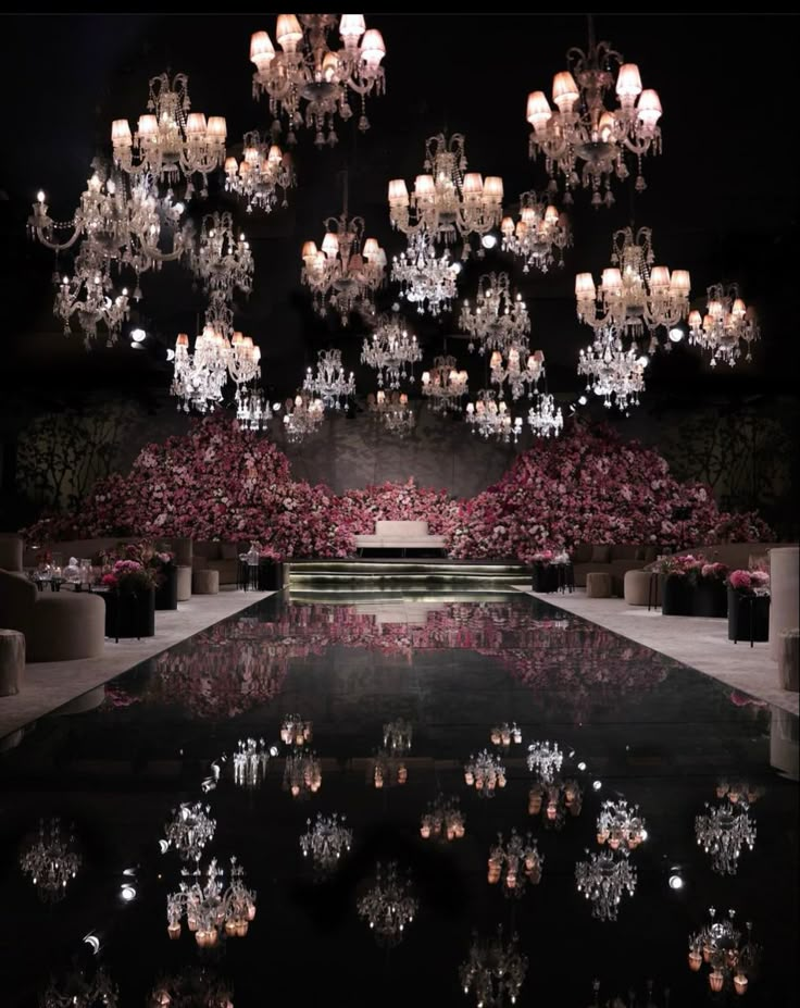 the chandelier is lit up and reflecting in the water