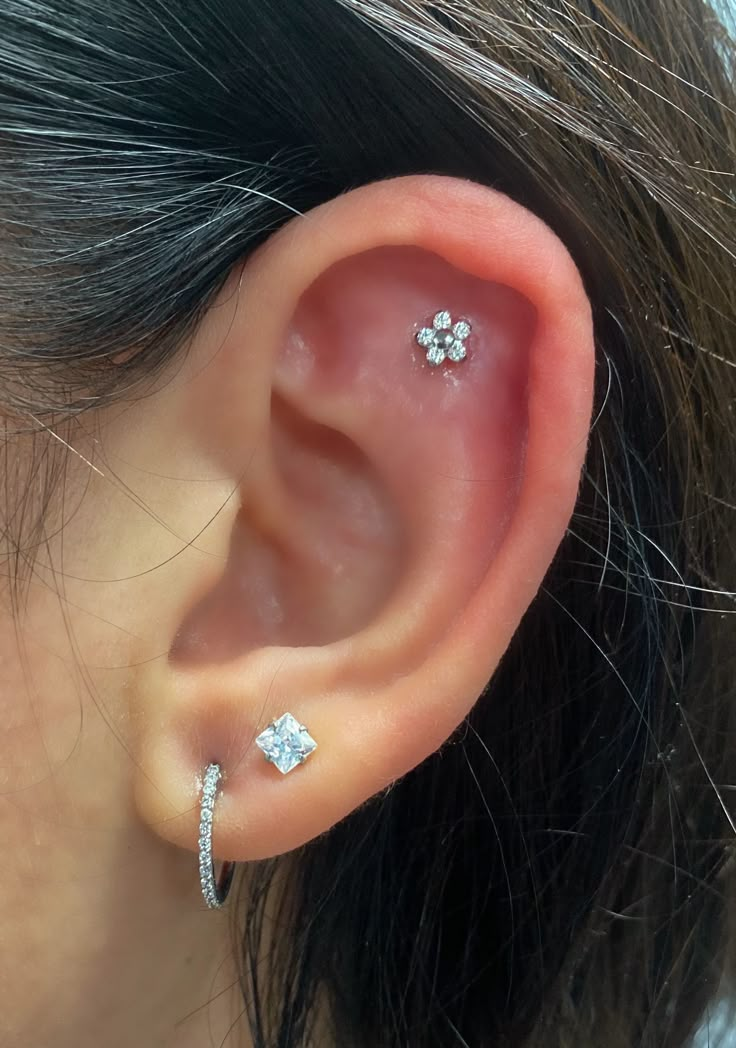 a close up of a person's ear with two piercings