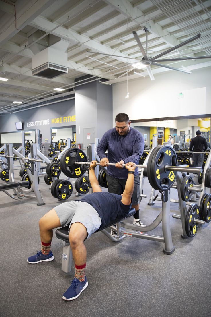 a man laying on top of a bench in a gym