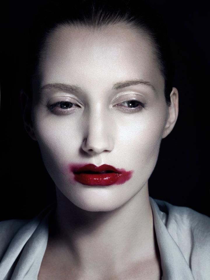 a woman with red lipstick on her face and white shirt, posing for the camera