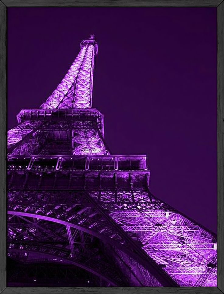 the eiffel tower lit up at night with purple lighting and stars in the sky