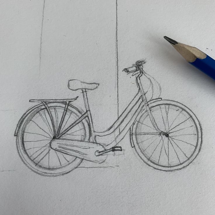 a pencil drawing of a bicycle on paper with a blue ballpoint pen next to it