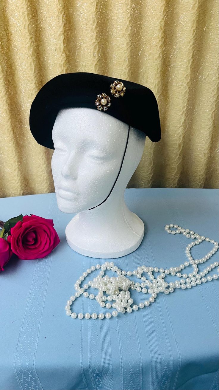 Get ready to turn heads with this absolutely fab 1950s Vintage Black Velour Pill Box Hat by the one and only Le Montet! This gem is the bee's knees for any vintage vixen looking to add a dash of pizzazz to her wardrobe. The black velour is softer than a kitten's meow, making it a comfy and chic choice for any occasion! And the rhinestone applique adds a sprinkle of glam--perfect for those high-society soirees! The hat has an asymmetrical bumper brim Pill Box style that screams drama--it will have you feeling like a Hollywood starlet.  The hat band measures approximately 21 inches--and is in excellent vintage condition, ready to grace your wardrobe and have you looking like a million bucks without breaking the bank! So, don't be a wallflower! Snatch up this stunning Le Montet hat and strut Pill Box Hat, Hollywood Starlet, Vintage Hat Boxes, Box Hat, Bee's Knees, Kitten Meowing, Pillbox Hat, Hat Boxes, Rhinestone Appliques