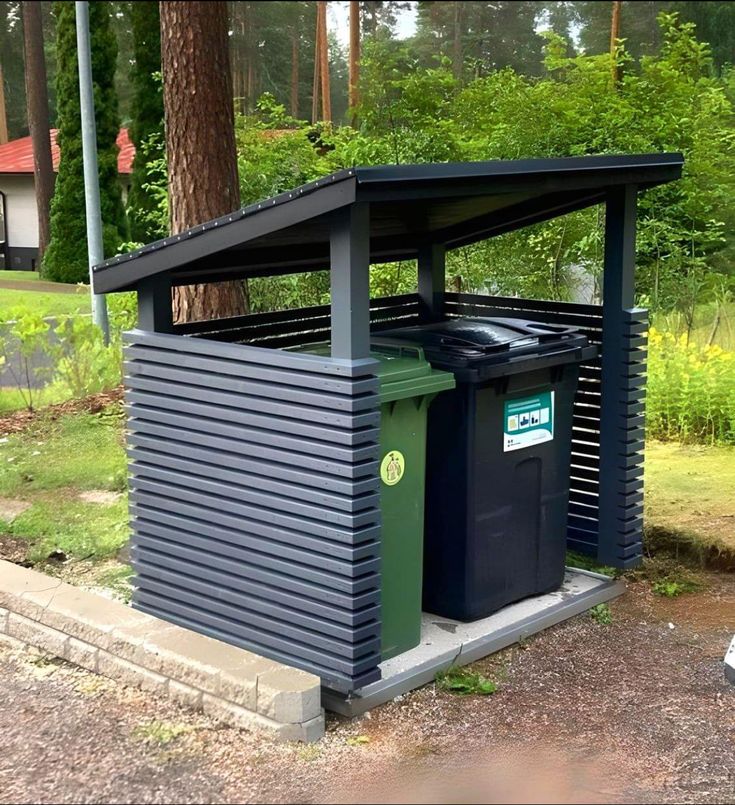 there is a small shelter with trash cans in it