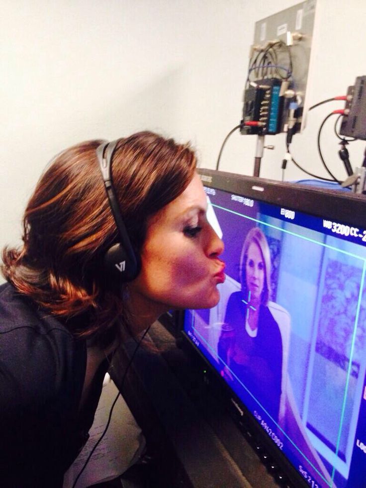 a woman with headphones on looking at a computer screen that is being used as a headset