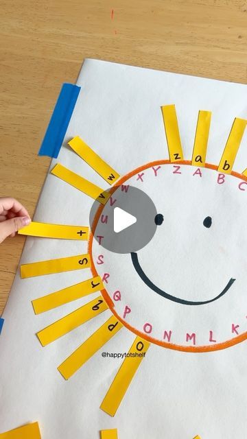 a child's hand is making a paper sun craft