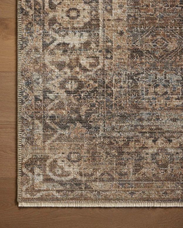 an area rug on top of a wooden floor with a brown and beige color scheme