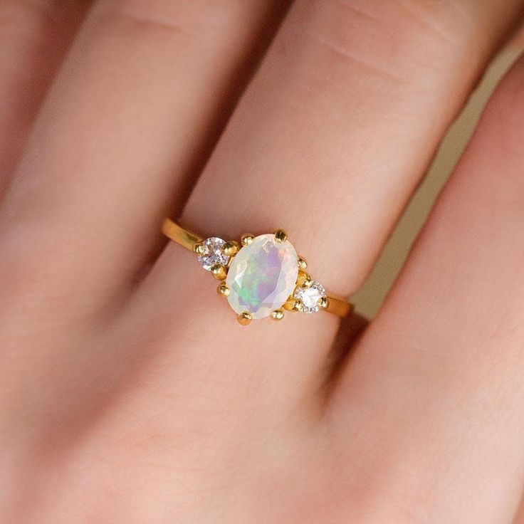 ✨ Extended Holiday Returns & Exchanges ✨ Items purchased between 15st November and 31st December 2024 can be returned or exchanged until 15th January 2025. Beautiful and sophisticated, our stunning opal ring features a natural opal with its dreamy iridescent glow, displaying a beautiful range of colours when it catches the light. Adorned with sparkly simulated diamonds, this gorgeous ring is meticulously handcrafted in solid sterling silver and plated with rhodium for a lustrous finish and durab Silver Opal Gemstone Ring In 14k Gold, Opal And Diamond Ring, Opal Multi-stone Ring As A Gift, White Moon-shaped Opal Ring Gift, Silver Multi-stone Opal Ring As Gift, Adjustable Nickel-free Opal Ring As A Gift, Fall Rings, Three Stone Rings, Halo Rings