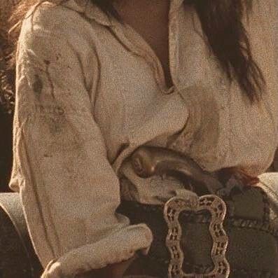 a woman with long hair sitting on a bench