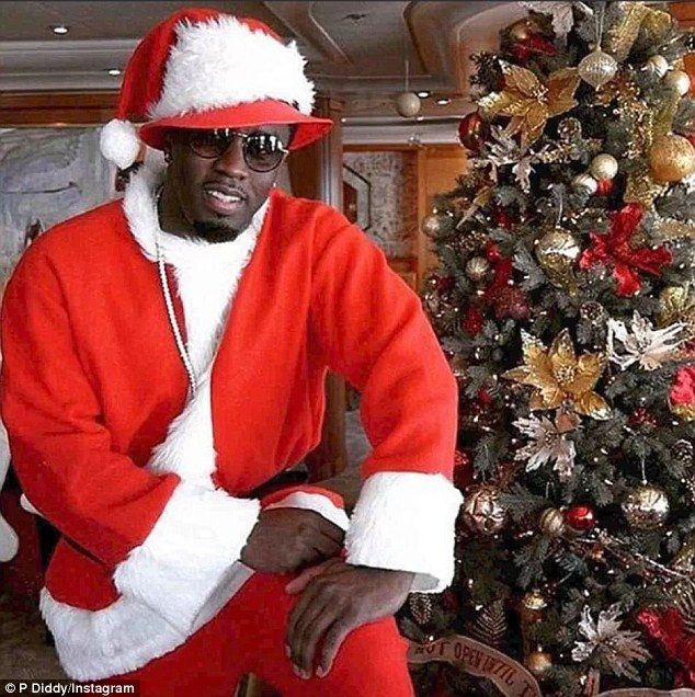 a man dressed as santa clause sitting in front of a christmas tree