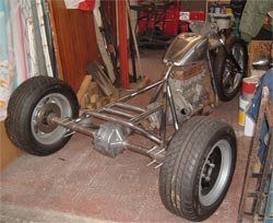 a motorcycle is parked in a garage next to other items and tools on the floor