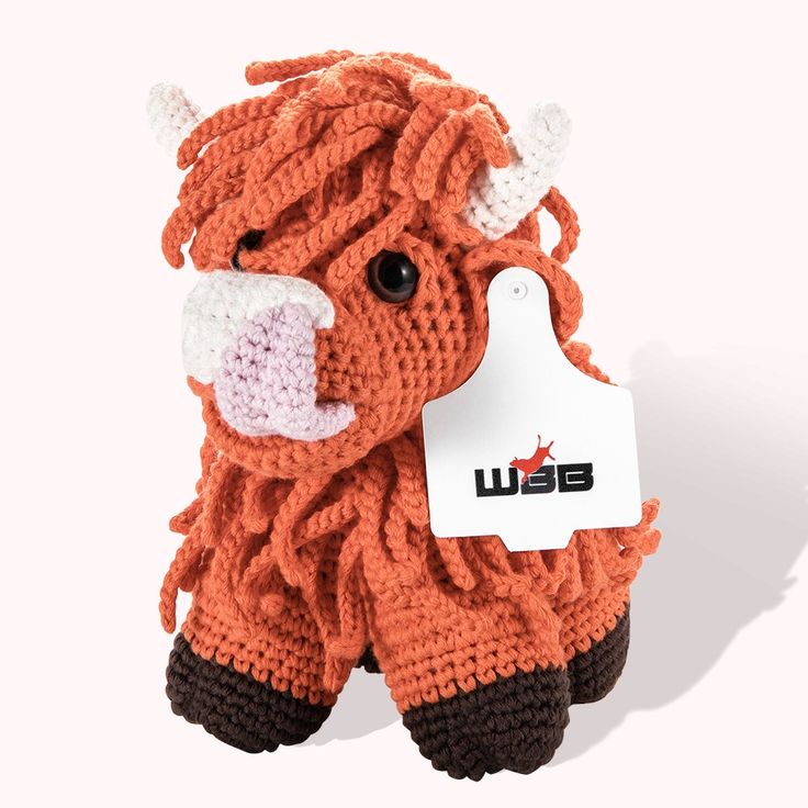 an orange knitted animal with a tag on it's ear