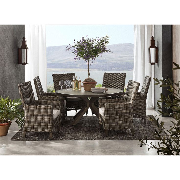 a dining room table with chairs and a potted plant