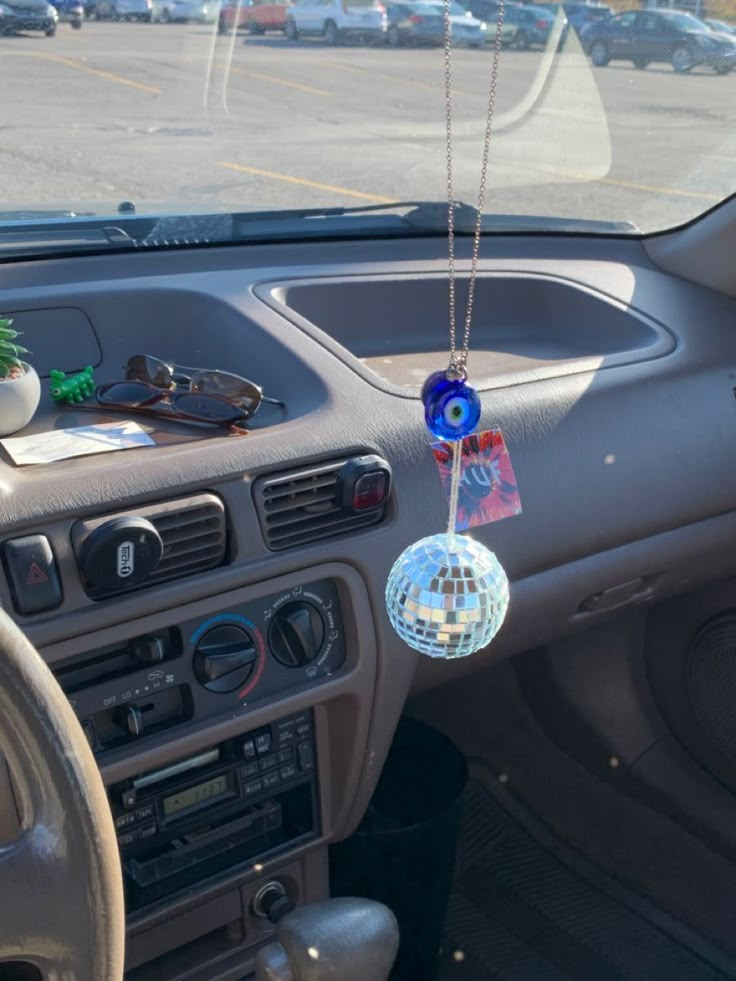 a car dashboard with a disco ball hanging from it's center console and dash board