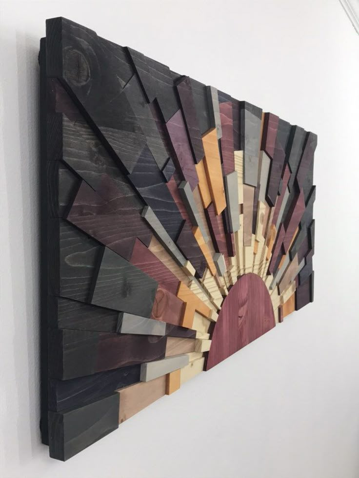 a wooden wall hanging on the side of a white wall with wood strips in it