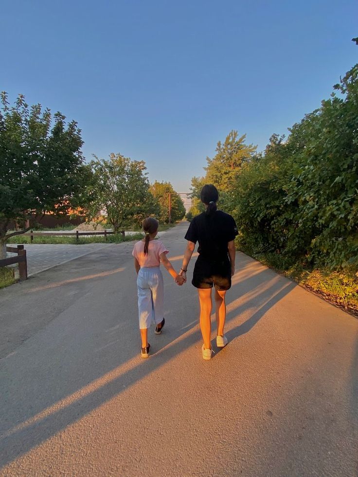 two people walking down the road holding hands