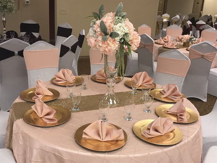 the table is set with pink napkins and gold plates