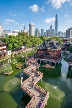 an aerial view of a river with buildings in the background and people walking across it