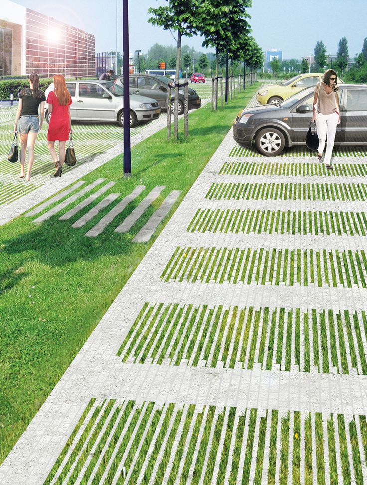 two women walking down a sidewalk next to parked cars and grass on the side walk