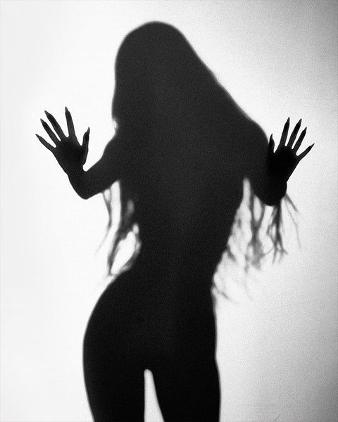 the shadow of a woman's body is shown with her hands in the air