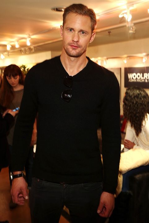 a man in a black sweater is posing for the camera