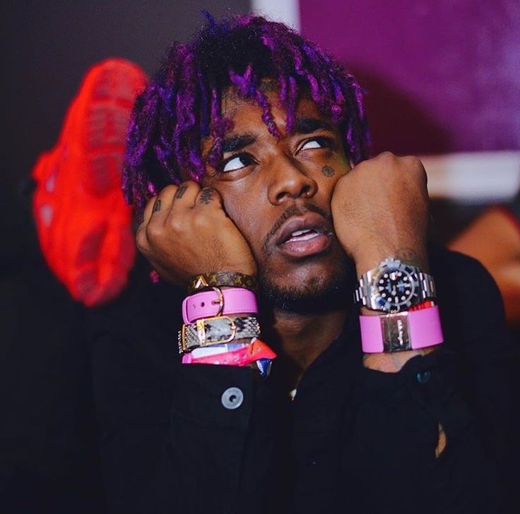 a close up of a person with purple hair and bracelets on their wrists