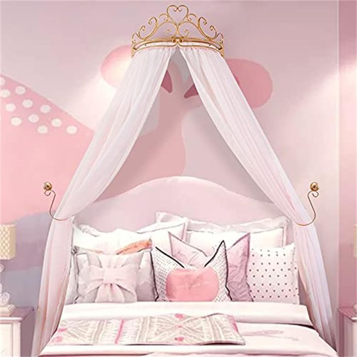 a bedroom with pink walls and white bedding in the center is a princess canopy bed