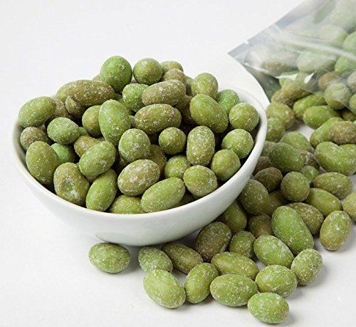 a white bowl filled with green beans next to a bag of peanuts