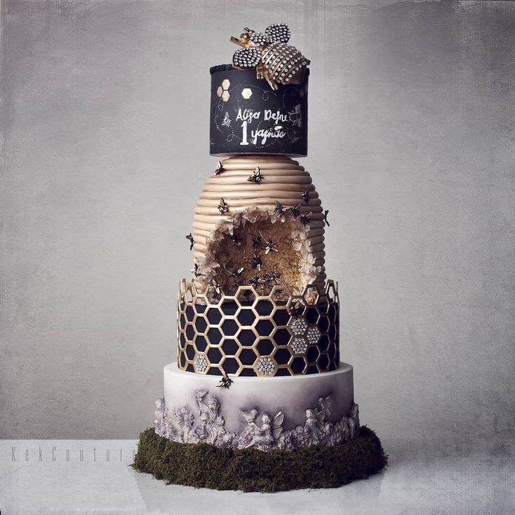 a three tiered cake decorated with honeycombs and beehives on top