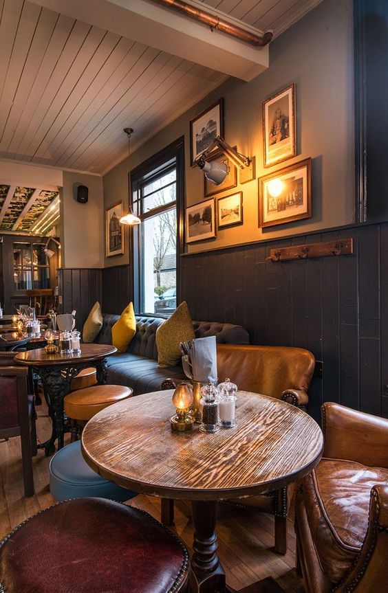 a table and chairs in a room with pictures on the wall