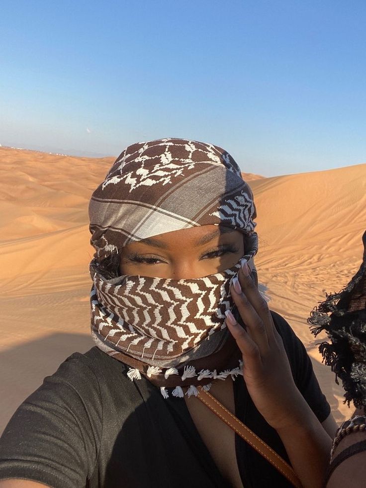 a woman with a scarf on her head in the desert