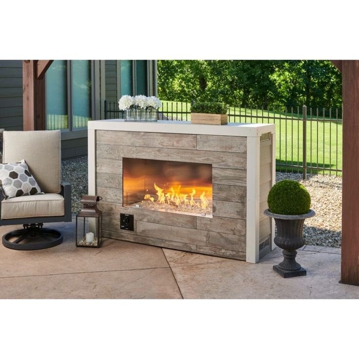 an outdoor fireplace in the middle of a patio