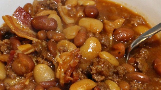 a white bowl filled with beans and meat