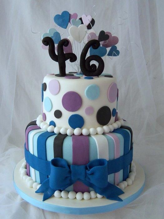 a birthday cake decorated with polka dots, hearts and numbers is on a white tablecloth