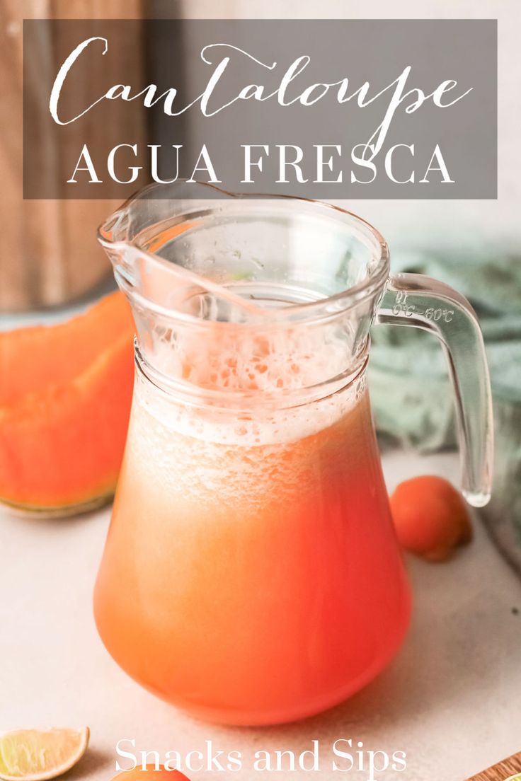 a pitcher filled with liquid next to sliced oranges