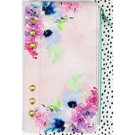 a pink and blue flowered notebook with gold buttons on the front, sitting on a polka dot background