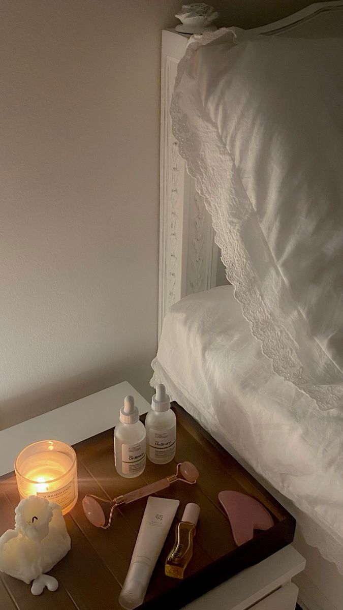 a night stand with candles, bottles and other items on it