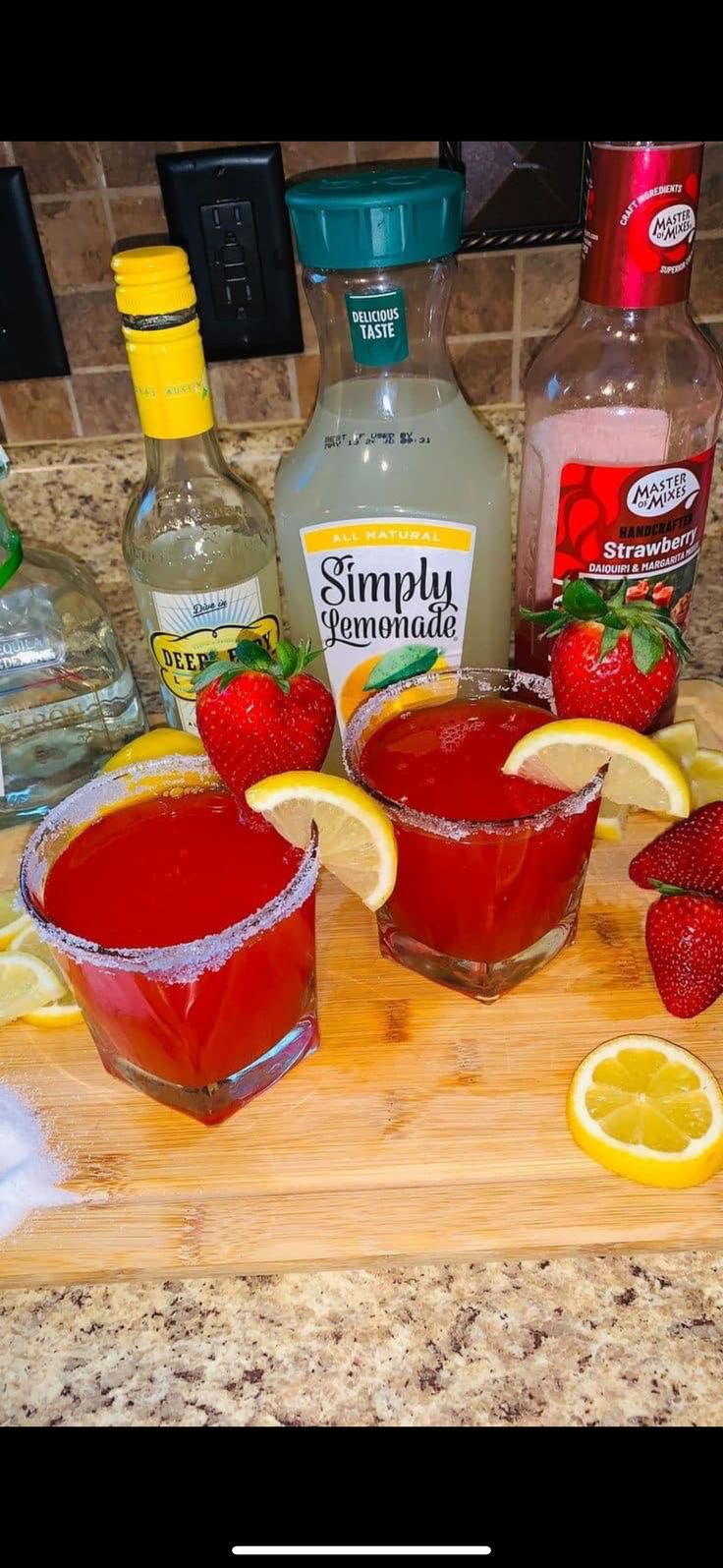 some strawberries and lemons are sitting on a cutting board