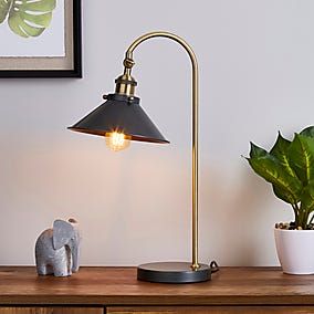 an elephant figurine sitting on top of a wooden table next to a lamp