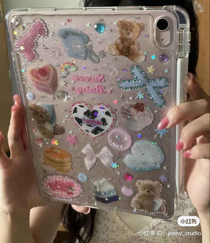 a woman holding up a clear case with lots of stickers on it