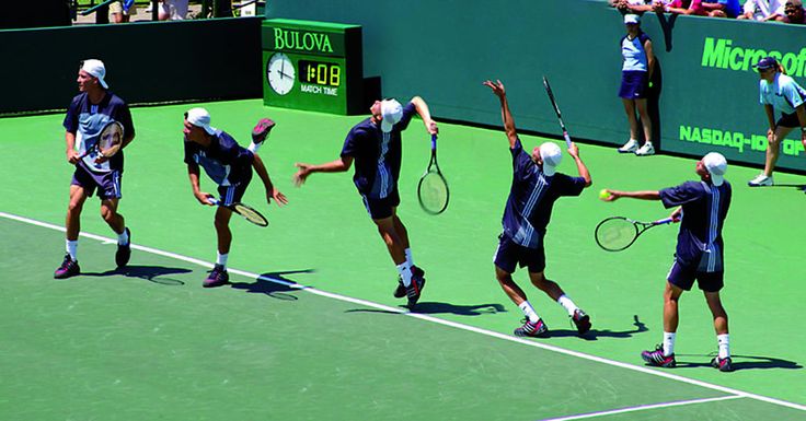 the men are playing tennis on the green court with their racquets in the air