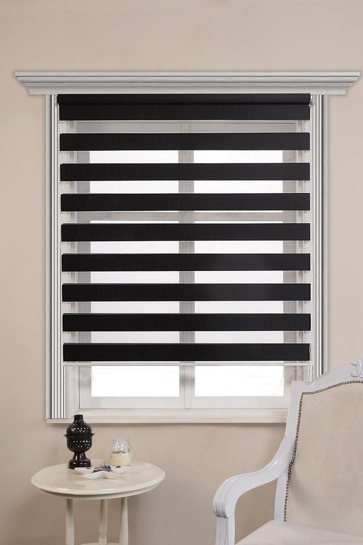 a black and white striped blind in a living room with a table, chair and window