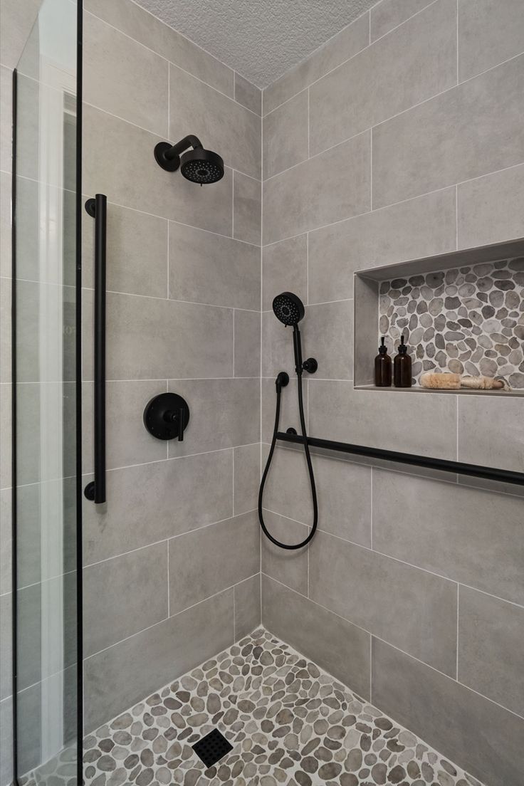 A transitional shower design with river rock floor and large format grey tile on the walls. Matte black fixtures. Restroom Remodel, Tub To Shower Remodel, Full Bathroom Remodel, Bathroom Redesign, Bathroom Remodel Designs, Bathroom Remodel Shower, Bathroom Inspiration Decor, Shower Remodel, Bathroom Remodel Master