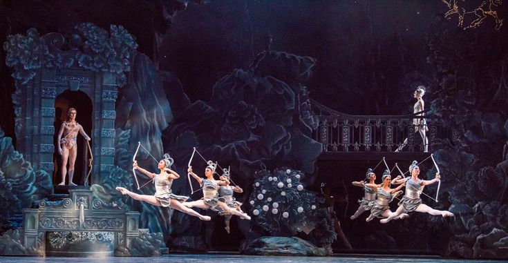 ballet dancers performing on stage in front of an audience