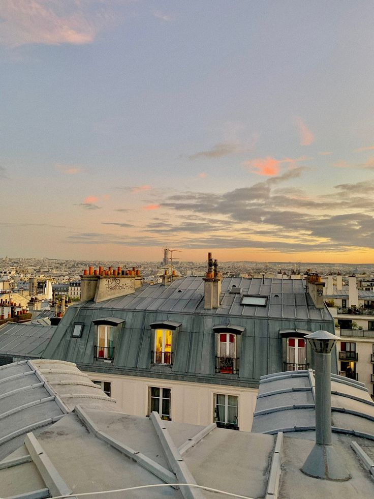 the roofs of many buildings are covered in snow and ice as the sun is setting