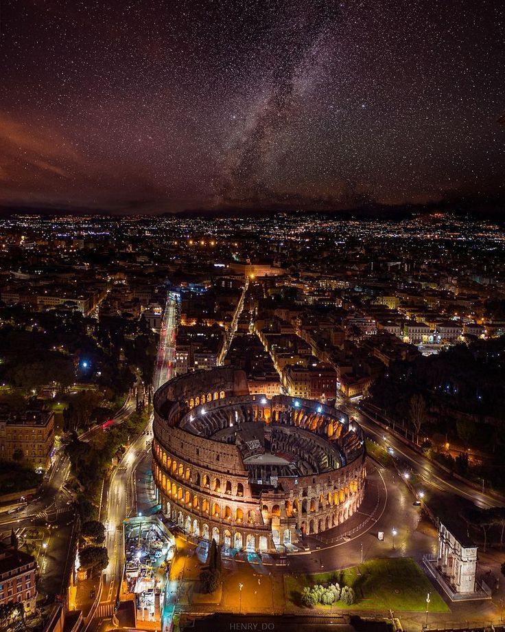 an aerial view of the city at night with stars in the sky and lights on buildings