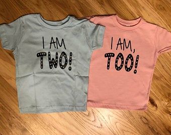 two t - shirts with the words i am two on them sitting on a wooden floor