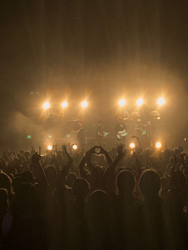 a group of people standing on top of a stage with lights in front of them