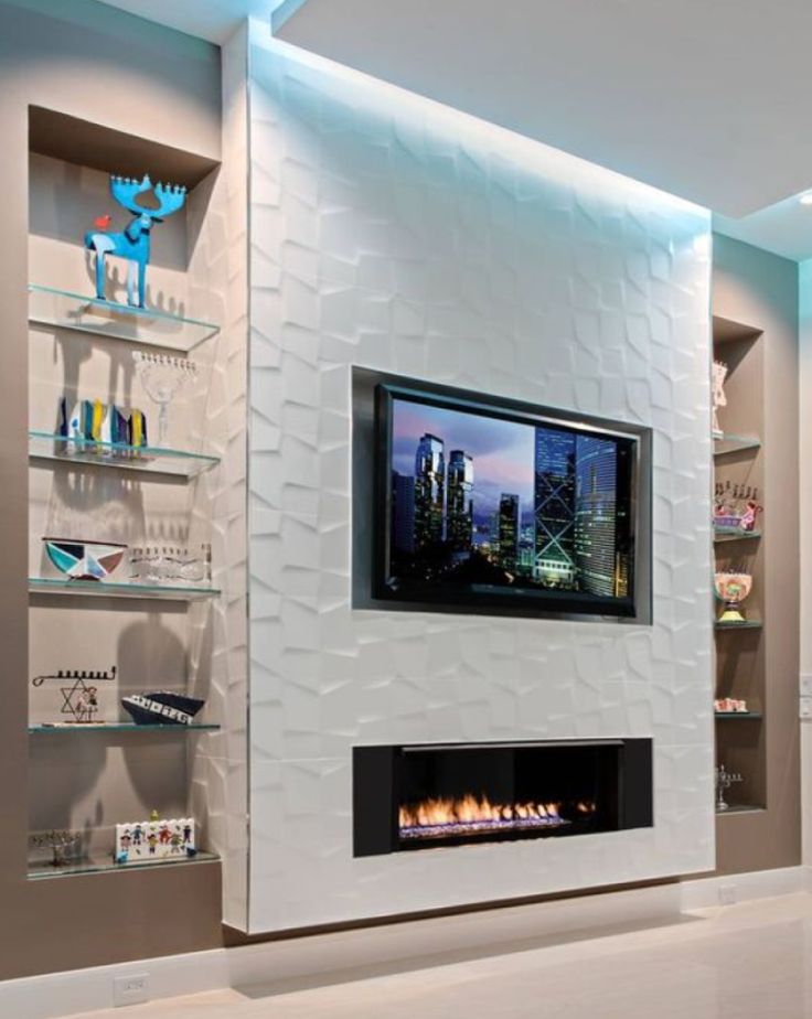 a living room with a fire place in the center and shelving on the wall