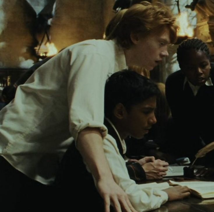 a group of people sitting at a table with books and papers in front of them